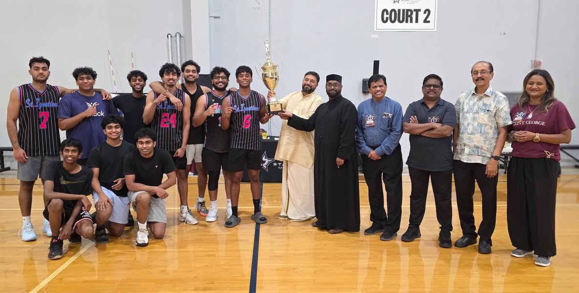 Players and guests with a tournament trophy on the basketball court