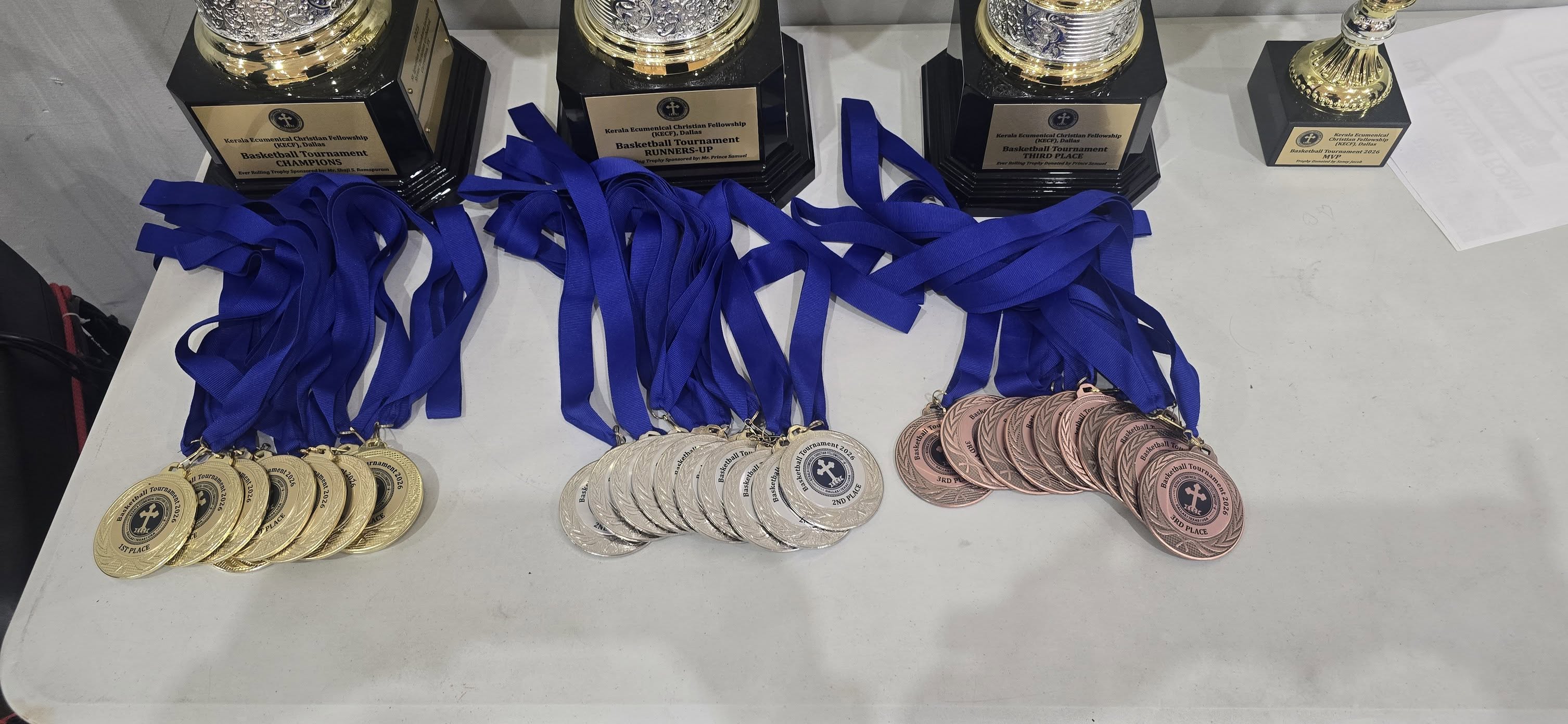 Tournament trophies and gold, silver and bronze medals with blue ribbons